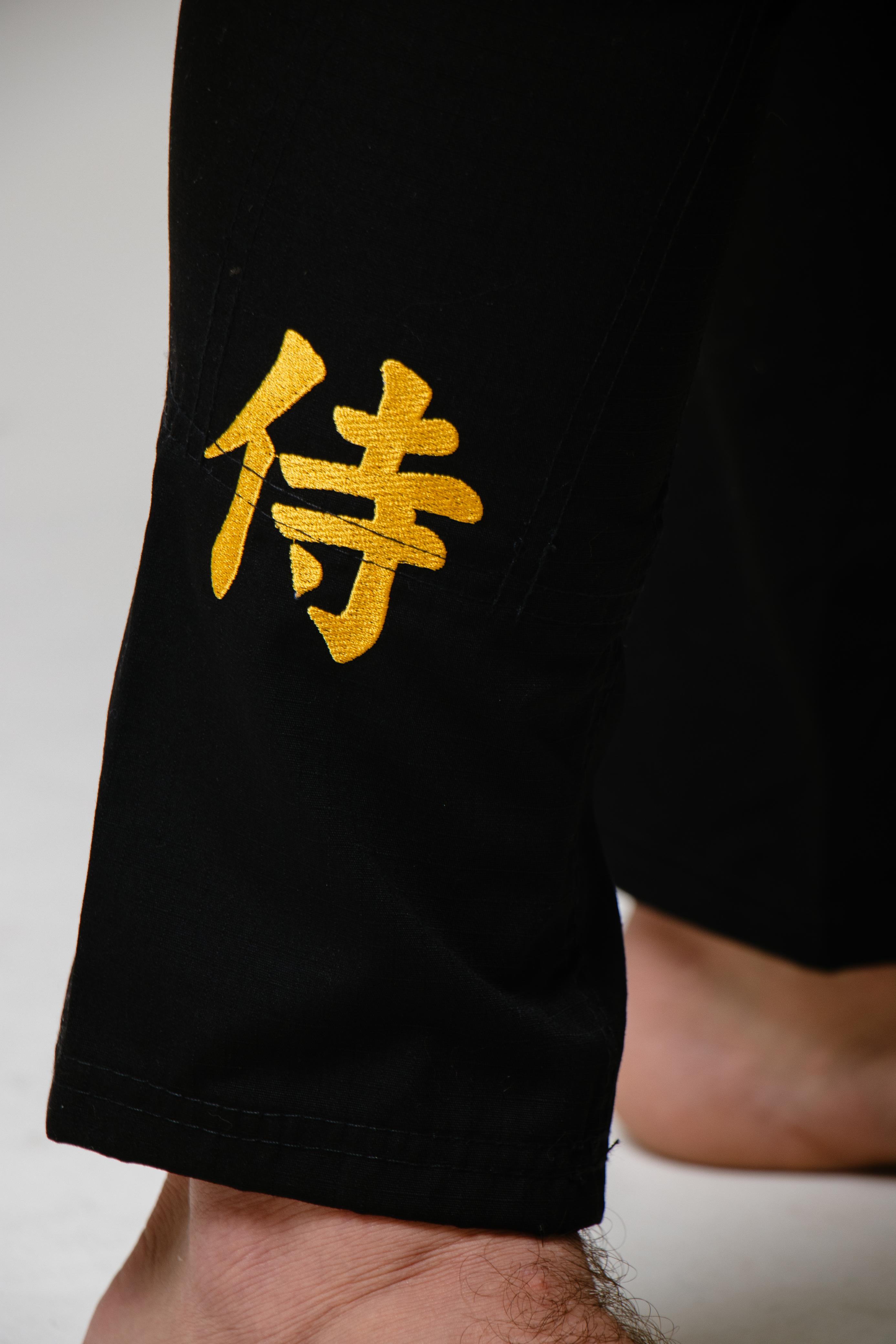Kanji samurai bordado em dourado na barra da calça